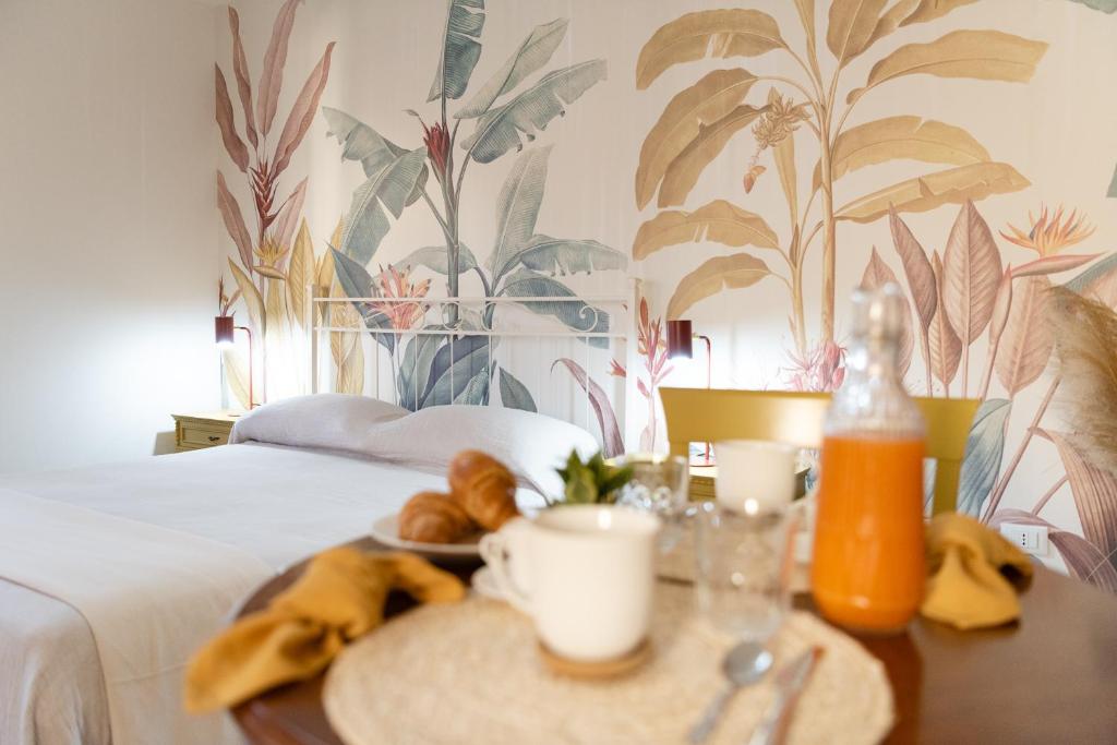 een hotelkamer met een bed en een tafel met eten bij BOTANIC GUESTHOUSE ESTE in Este