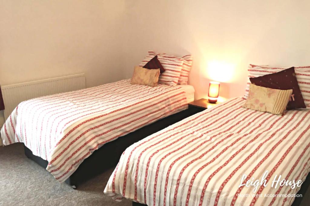 two beds sitting next to each other in a room at Leigh Accommodation in Leigh