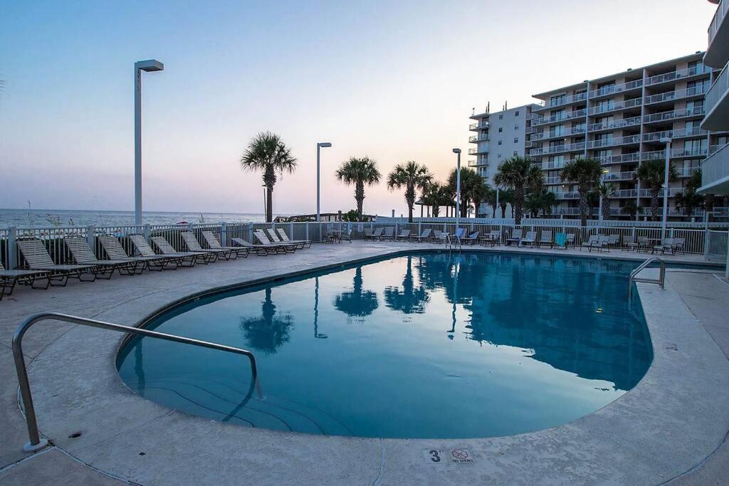 ein großer Pool mit Stühlen und ein Gebäude in der Unterkunft Tradewinds 808 - NEW Rental- 1bd/2bath-Luxury Comfort in Orange Beach