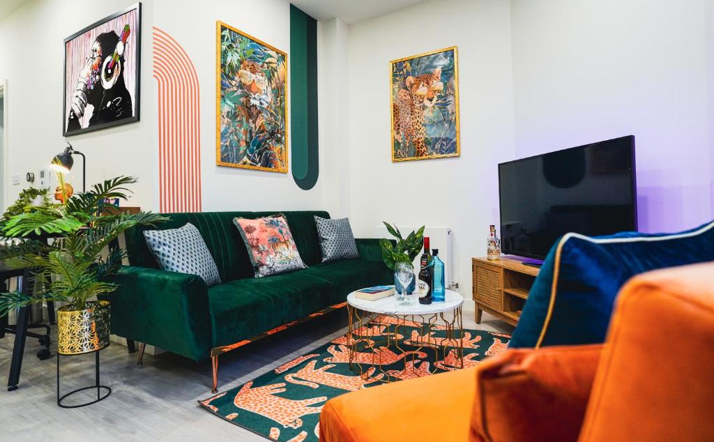 sala de estar con sofá verde y TV en Spacious Luxury Apartment in Stevenage, Sleeps 6, with Free Parking, and Free Wi-Fi, en Stevenage