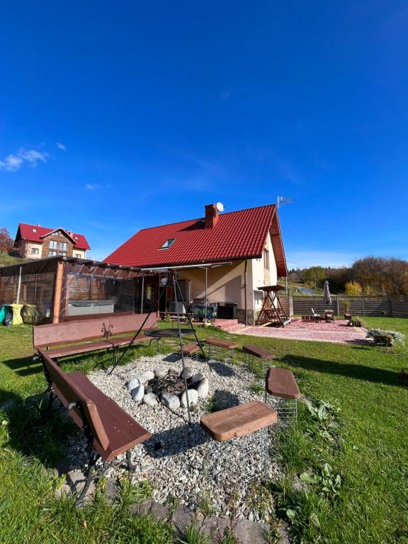 a backyard with a fire pit and a house at Domek w Chmurach in Kicznia