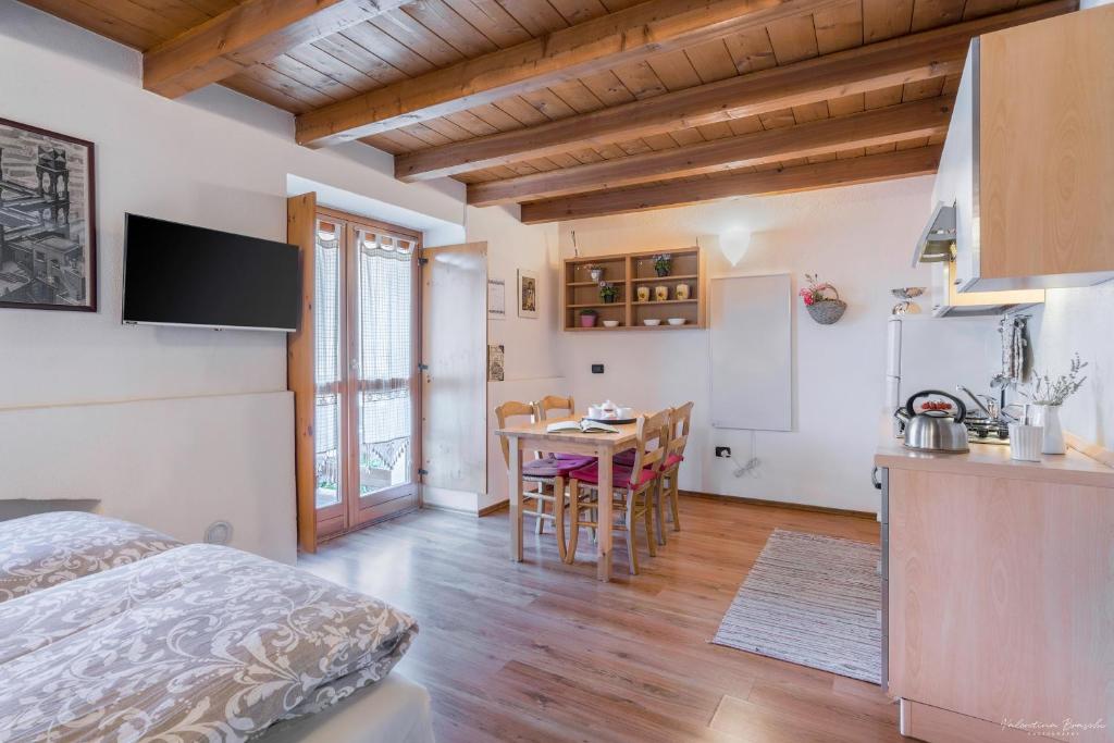 um quarto com uma cama e uma cozinha com uma mesa em Monolocali di Cà Selvetta Holiday Houses em Morbegno