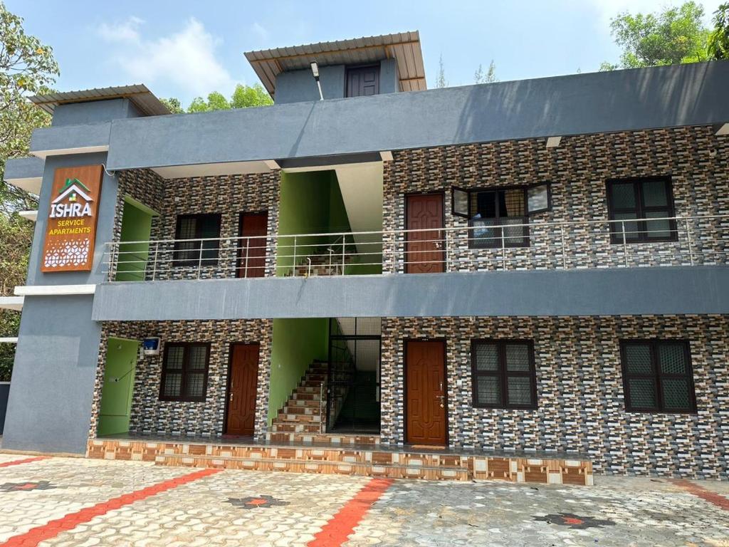 a brick building with a balcony on top of it at ISHRA SERVICE APARTMENTS in Dharmastala