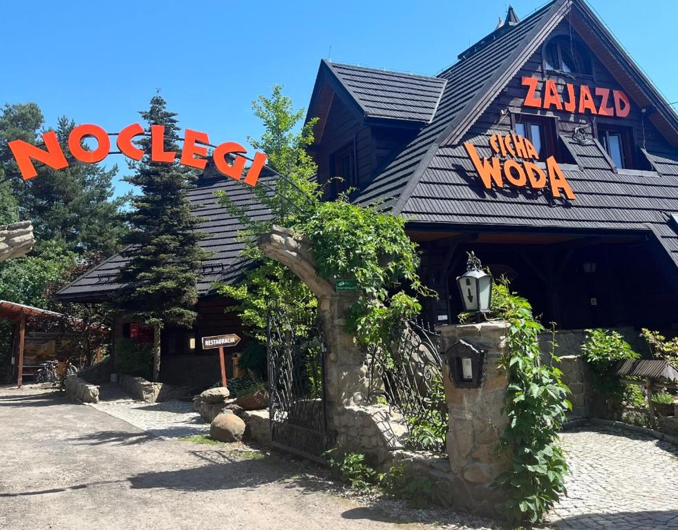 budynek z szyldem na froncie w obiekcie Zajazd Cicha Woda w mieście Maniowy
