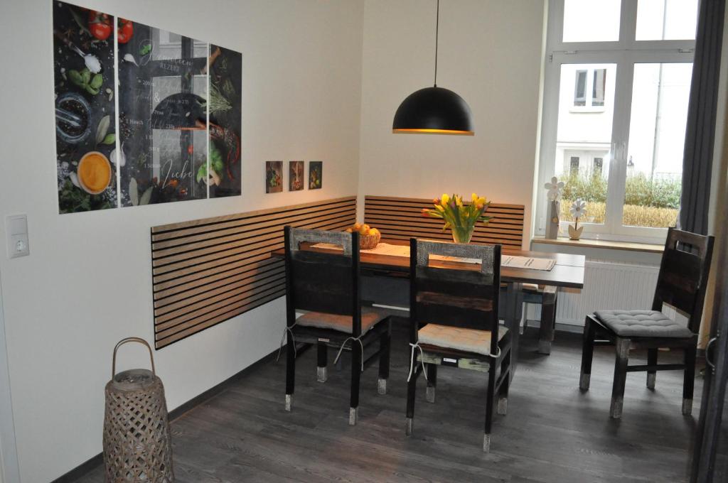 ein Esszimmer mit einem Holztisch und Stühlen in der Unterkunft ElisaBett Erfurt - Eine Wohnung bis 6 Personen - 4 Schlafzimmer und 2 Bäder in Erfurt