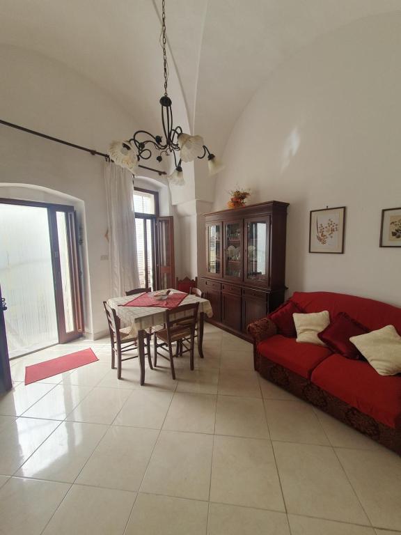 sala de estar con sofá rojo y mesa en Da Nonna Lucia, en Roccaforzata