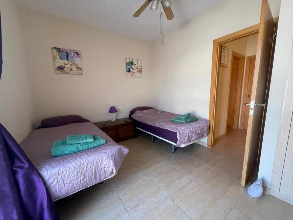 una habitación con dos camas y un espejo en Mi casa su casa, en Caleta de Fuste