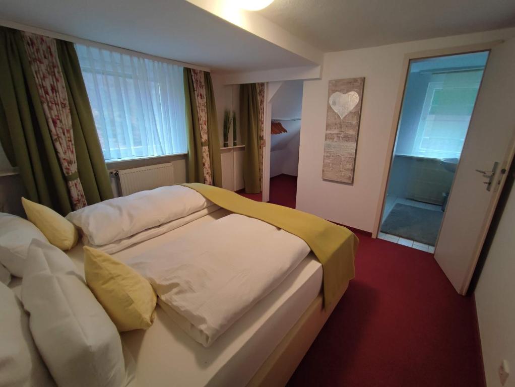 a hotel room with a bed and a window at Pension Forelle in Forbach
