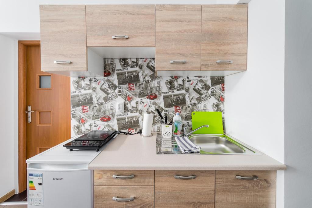 a kitchen with a sink and a collage of photos at JM Rooms Lubicz II in Krakow