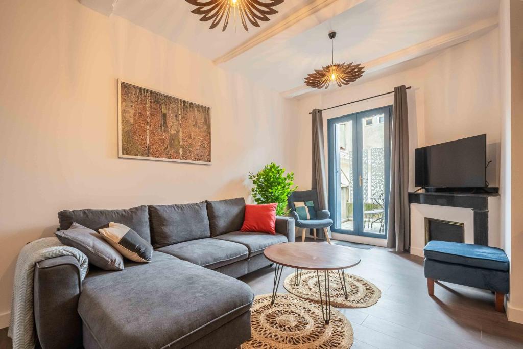 sala de estar con sofá y TV en Le Solarium - Terrasse - Climatisation en Narbonne