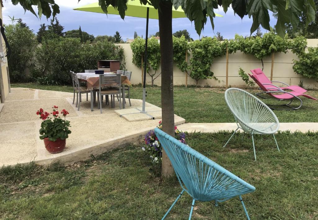 2 chaises et une table dans la cour dans l'établissement La petite maison des Muses Arles, à Arles