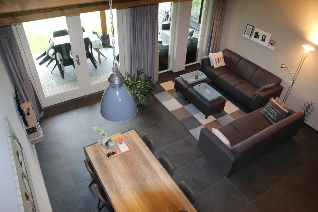 een woonkamer met een bank en een tafel bij Vakantiehuis Weideblik in Biezenmortel