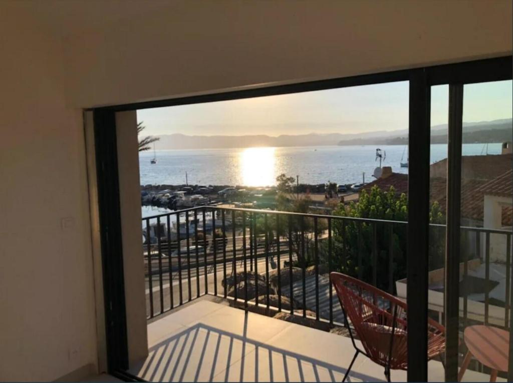 a room with a balcony with a view of the ocean at Le retour in Saint-Cyr-sur-Mer