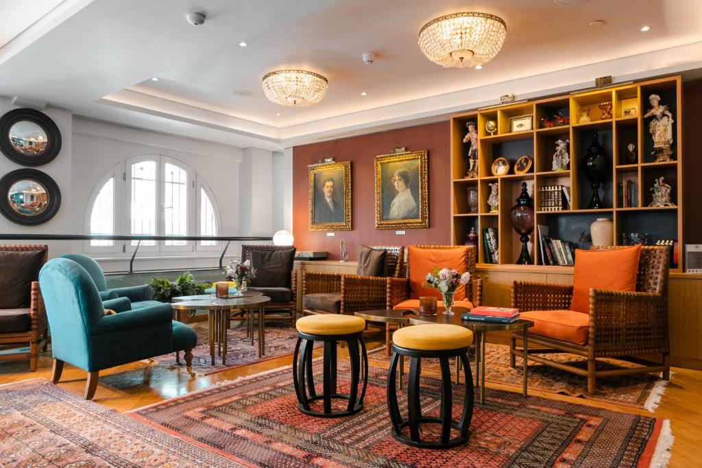 a living room with chairs and tables at The Excelsior - Small Luxury Hotels of the World in Thessaloniki