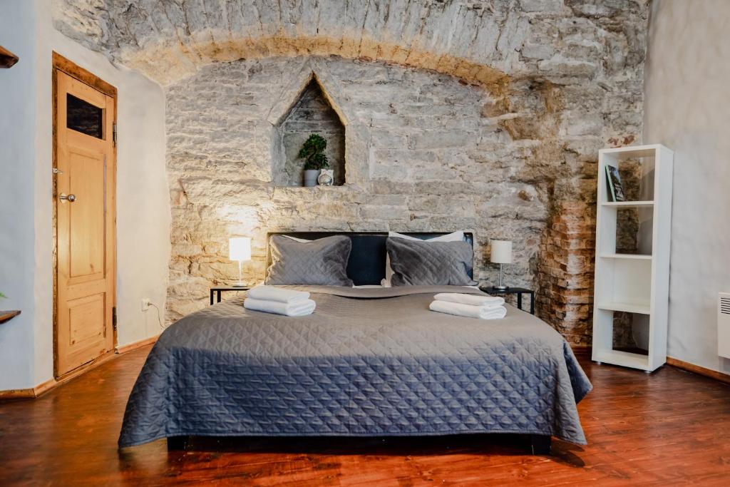 - une chambre avec un grand lit dans un mur en pierre dans l'établissement Dream Stay - Old Town City Wall Studio Apartment, à Tallinn