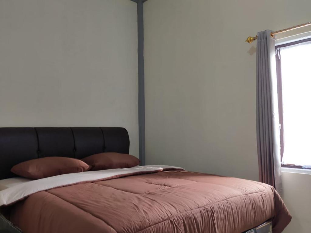 una camera da letto con un grande letto e una finestra di Tingang84 Guesthouse a Palangkaraya