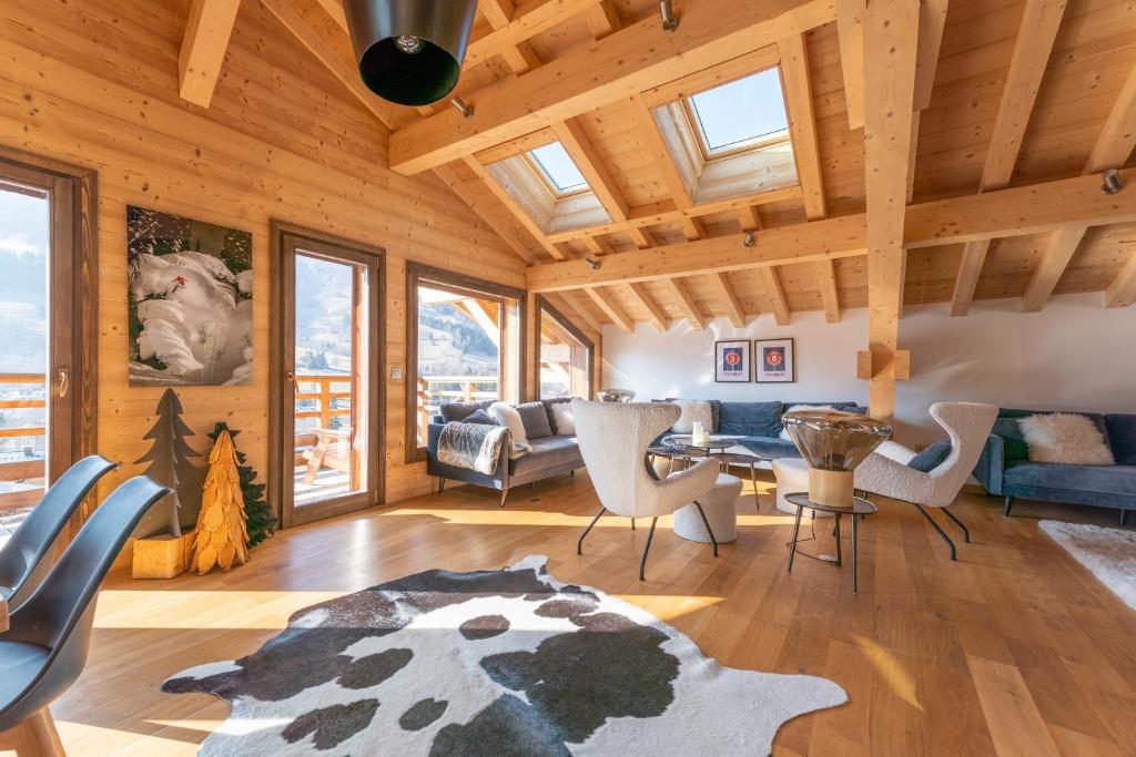 a living room with wooden ceilings and a table and chairs at Chalet les 3 cerfs in Les Contamines-Montjoie