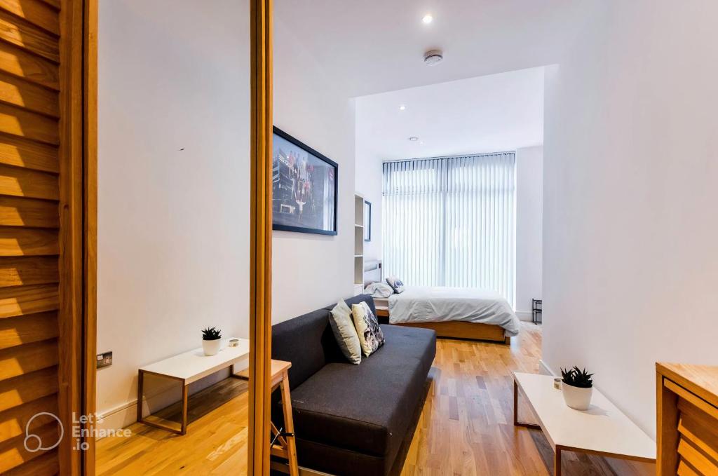 ein Wohnzimmer mit einem Sofa und einem Bett in der Unterkunft Fully Equipped Studio in Greenwich - 1 min to Station in London