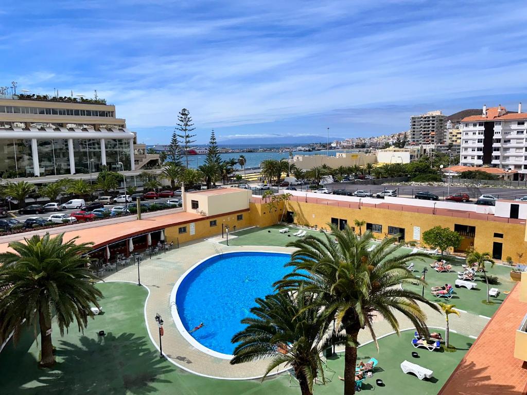 a view of a resort with a swimming pool and palm trees at Pier View Los Cristianos Free WiFi in Los Cristianos