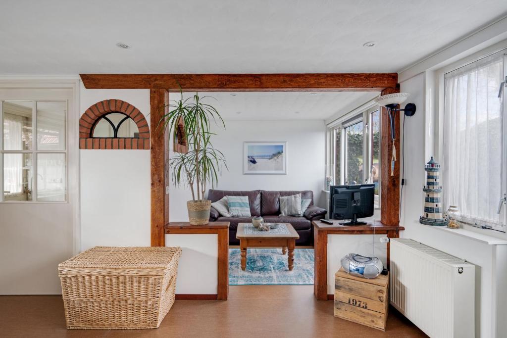 a living room with a couch and a tv at 't Zwanennest in Egmond aan den Hoef