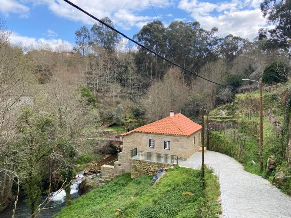 une petite maison sur une colline à côté d'une rivière dans l'établissement Casa Posto da Guarda Fiscal, à Melgaço