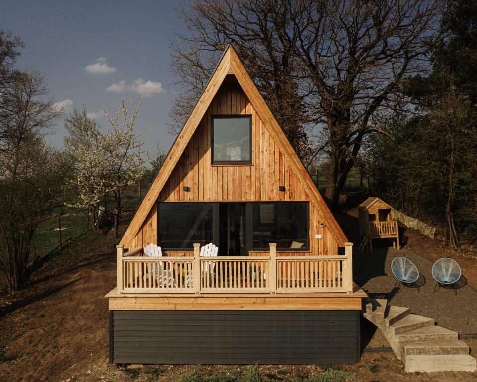 uma grande casa de madeira com um alpendre e uma janela em Kanyar - Nordic Cabin em Zebegény