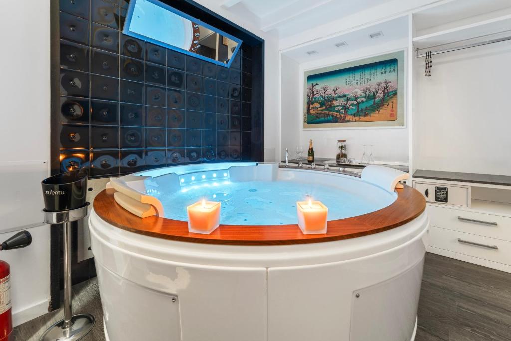 a jacuzzi tub in a bathroom with candles at Ukiyo Suites And Rooms in Cagliari