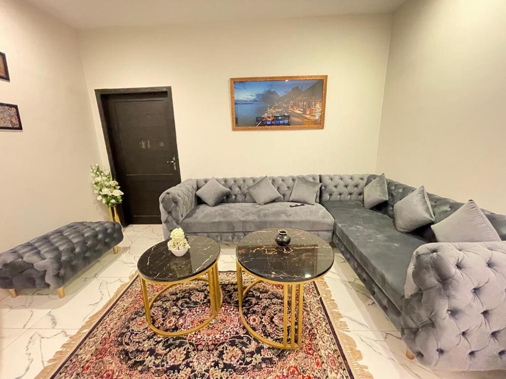 sala de estar con sofá y 2 mesas en Stunning and Peaceful 1BHK,Free Parking + WIFI, en Islamabad