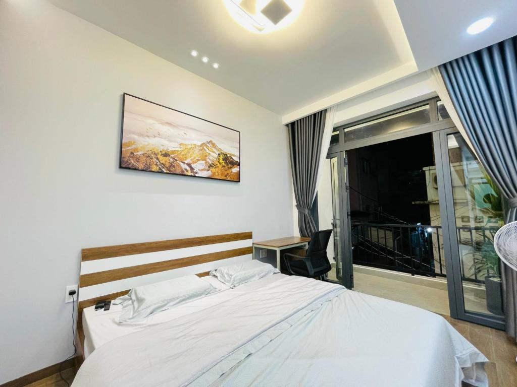 a bedroom with a white bed and a window at Thai Van Home in Ho Chi Minh City