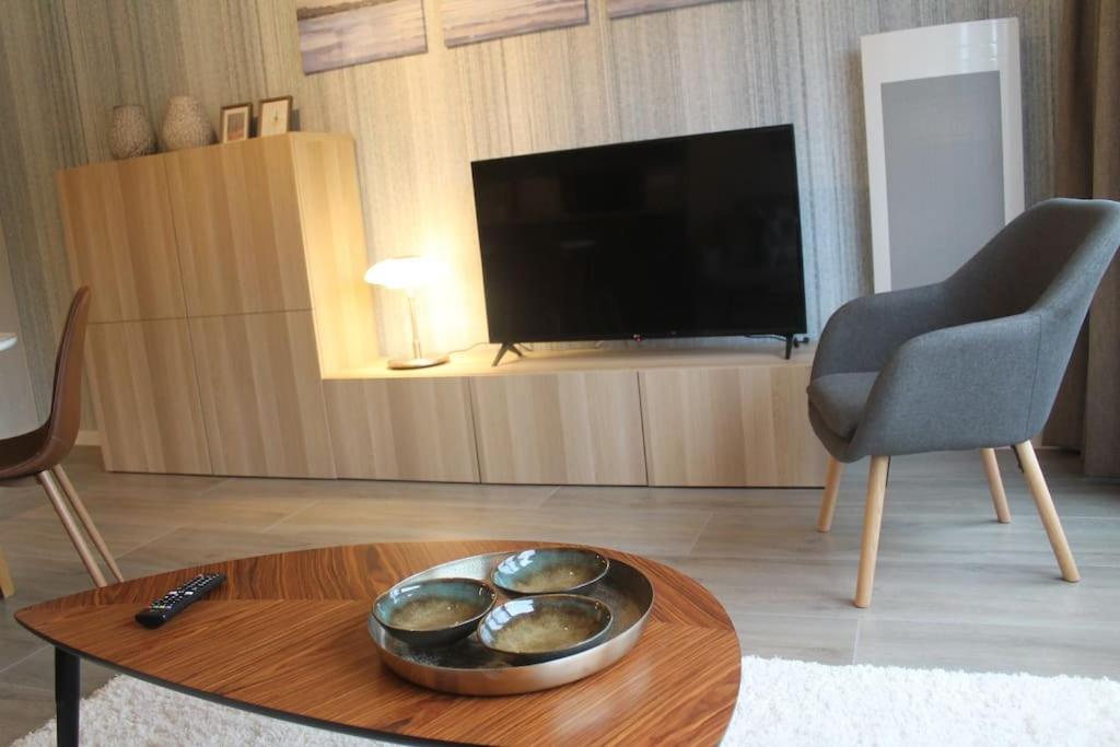 uma sala de estar com televisão e uma tigela sobre uma mesa em Studio Adèle, op en top comfort & kwaliteit em Middelkerke
