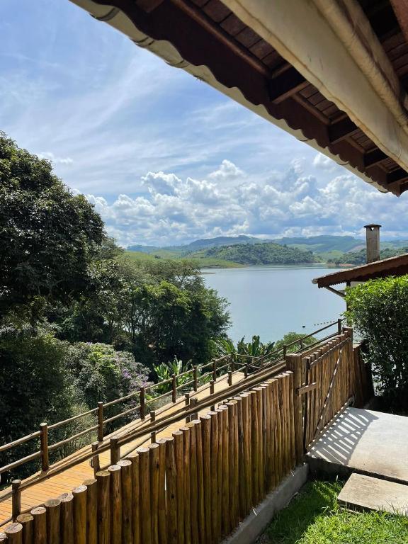 a view of a lake from a wooden fence at Chalé das Águas in Igaratá