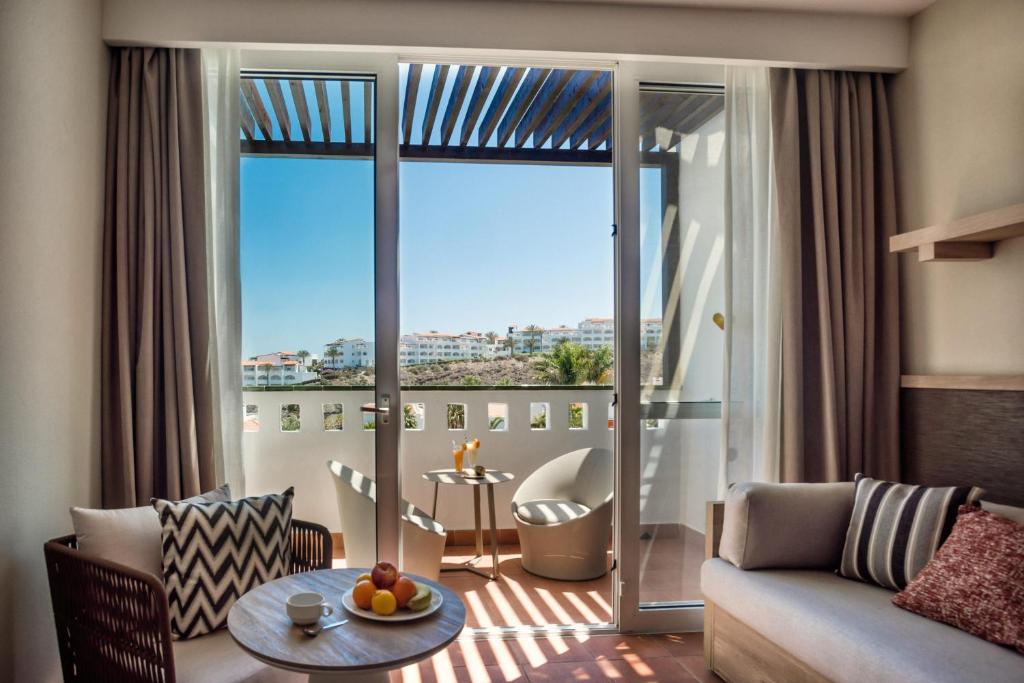 a living room with a couch and a large window at Fuerteventura Princess in Playa Jandia