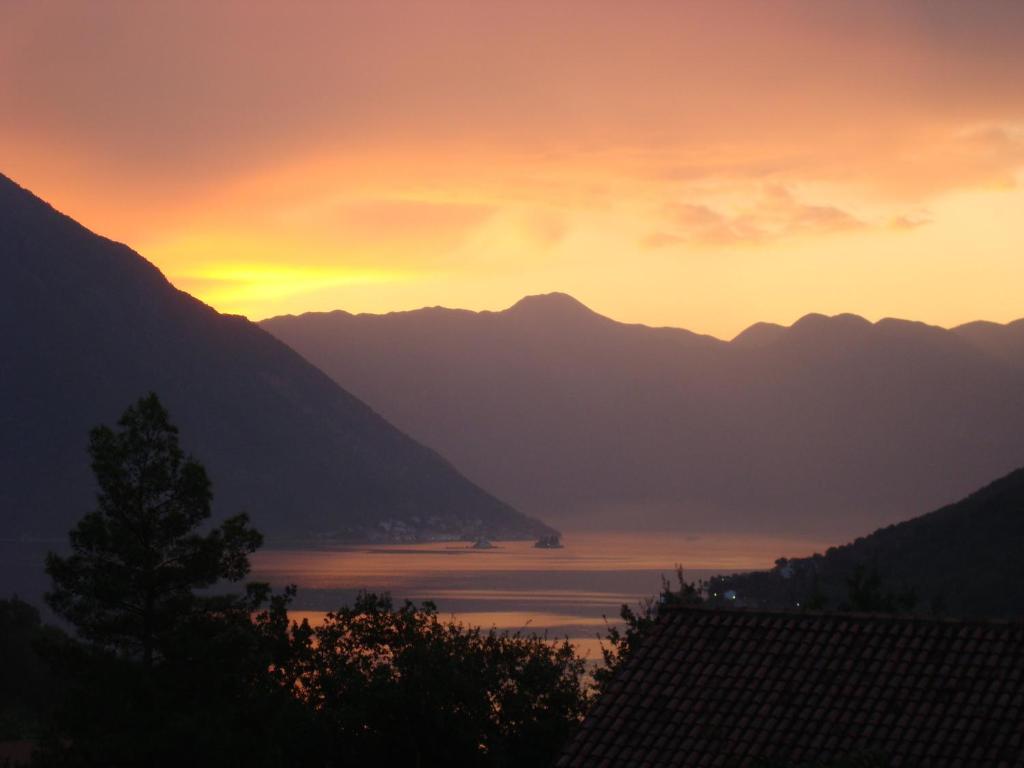 een uitzicht op een meer bij zonsondergang met bergen bij Villa Rosa in Donji Morinj