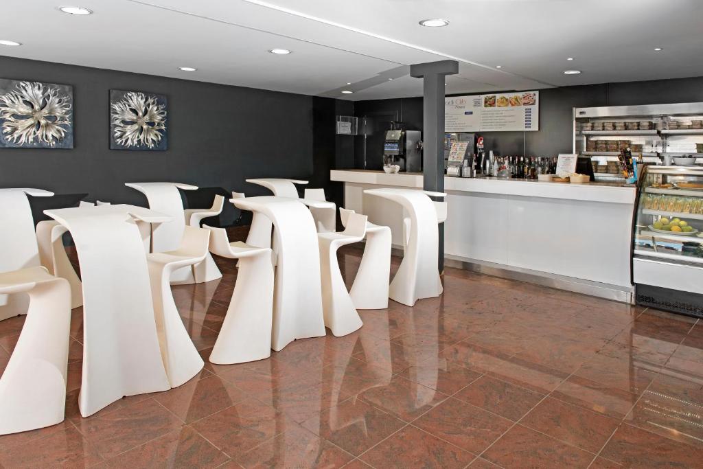 a row of white chairs in a restaurant with a counter at Mogan Princess & Beach Club in Taurito