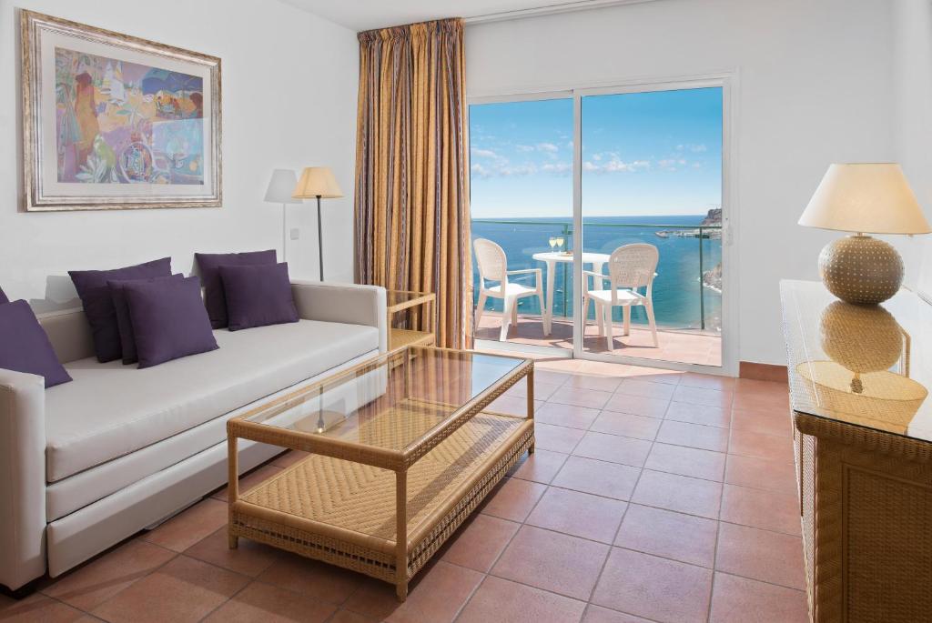a living room with a couch and a view of the ocean at Mogan Princess & Beach Club in Taurito