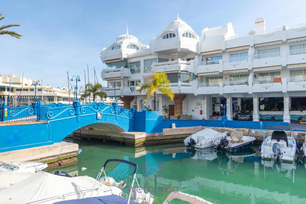 un puerto deportivo con barcos en el agua junto a un edificio en weforyou Isla de Poniente 2 Bedrooms and Parking, en Benalmádena