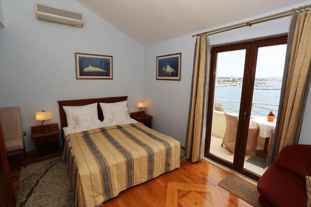 sypialnia z łóżkiem i dużym oknem w obiekcie Villa Ivana B&B w mieście Zadar