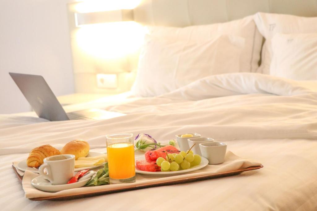 a tray of fruit and juice on a bed at Hotel Travel Park Lisboa in Lisbon