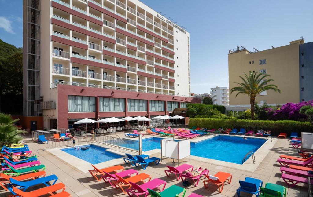 a pool with lounge chairs and a hotel at Medplaya Hotel Santa Monica in Calella