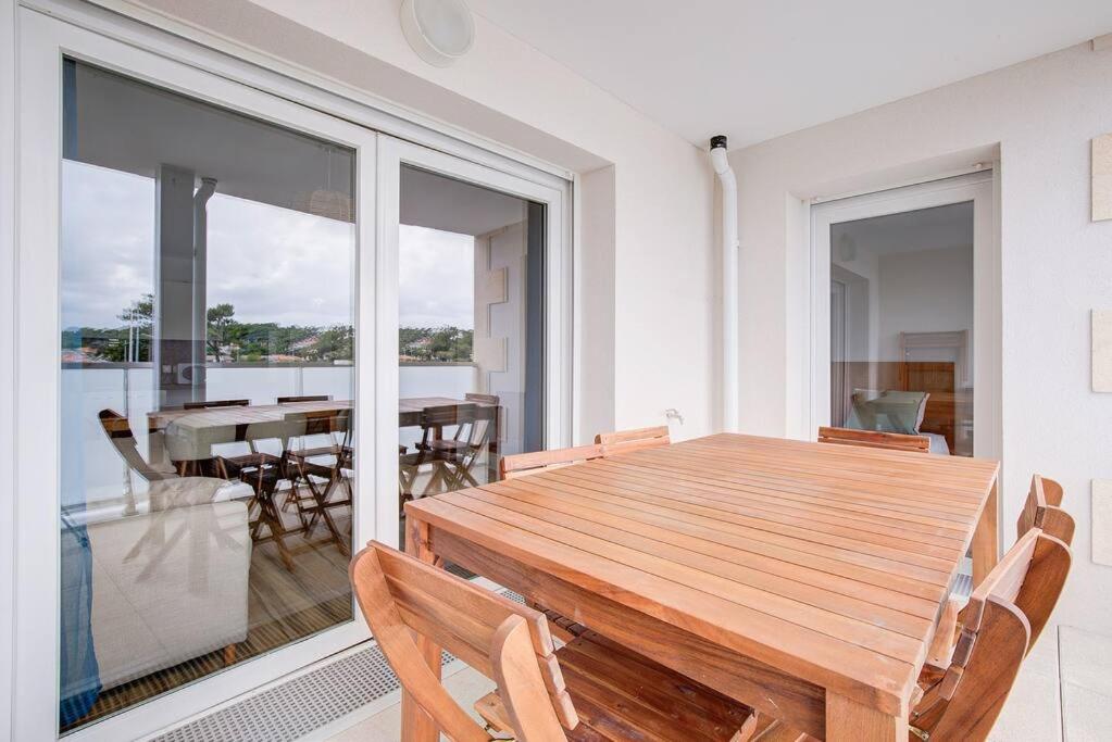 uma sala de jantar com uma mesa de madeira e cadeiras em Très belle appartement haut standing em Lacanau-Océan