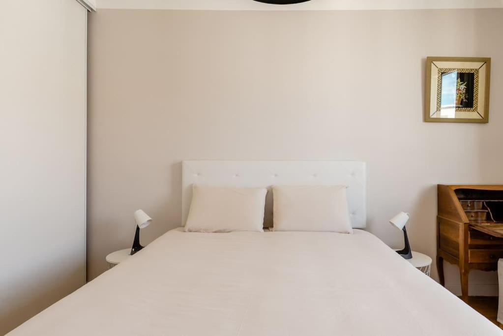 a bedroom with a white bed with two lamps at LET'S - 50 m² - T2 Part Dieu / centre - Wifi in Lyon
