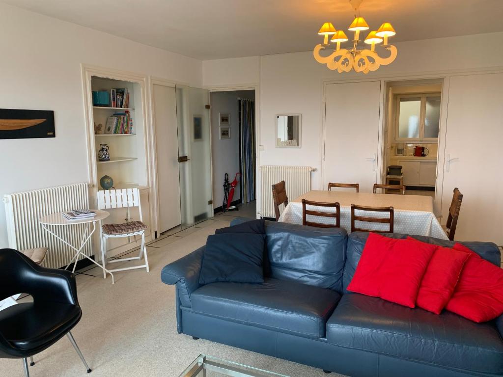 sala de estar con sofá azul y almohadas rojas en Appt de 6 pers - Vu mer proche centre-ville, en Le Touquet-Paris-Plage