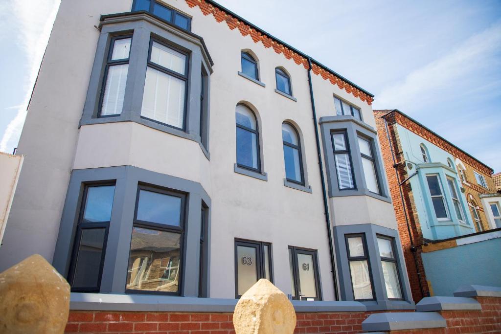 a white building with black windows on a street at Withnell Stays - Apartment Four - Ground Floor in Blackpool