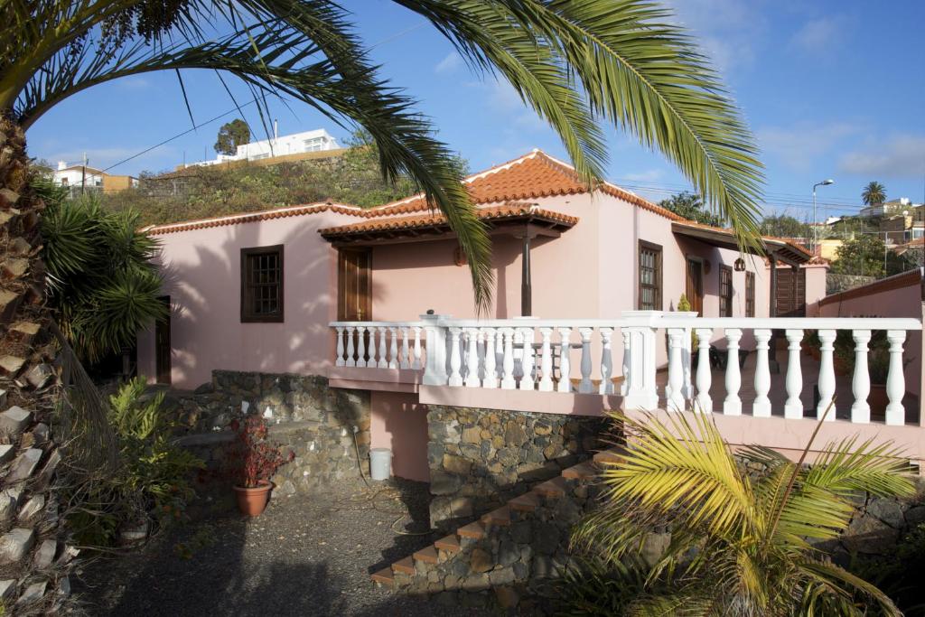 uma casa com uma varanda branca e palmeiras em Casa Rural Olga em El Paso