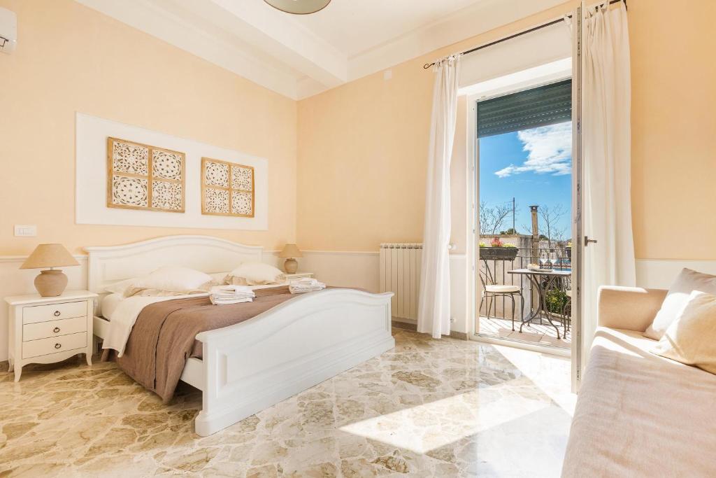 ein Schlafzimmer mit einem Bett und einem großen Fenster in der Unterkunft Dimora Le Tre Muse Guesthouse in Lecce