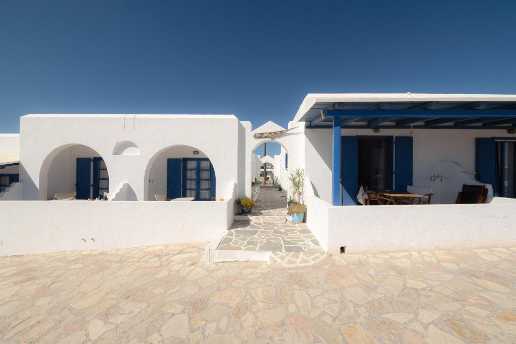 Cette maison blanche dispose de portes bleues et d'une terrasse. dans l'établissement Christina's House, à Koufonisia