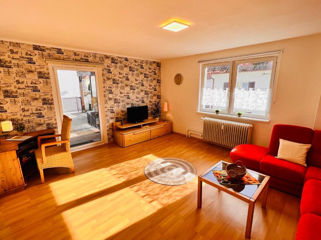 sala de estar con sofá rojo y mesa en Apartment Alexandra - Handwerker willkommen, Parkplatz, Küche, WLAN, en Malterdingen