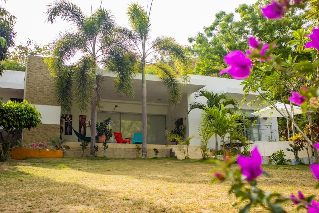a house with palm trees in front of it at Casa de campo en Cienaga de Oro 