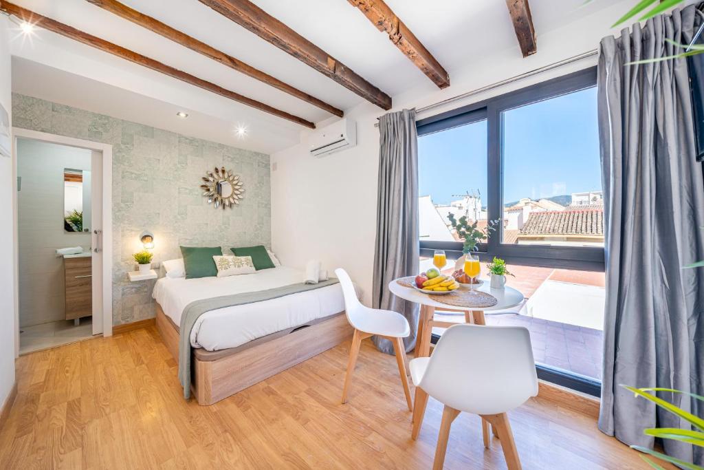 1 dormitorio con 1 cama, mesa y sillas en OLD TOWN - Cozy Apartment, en Málaga