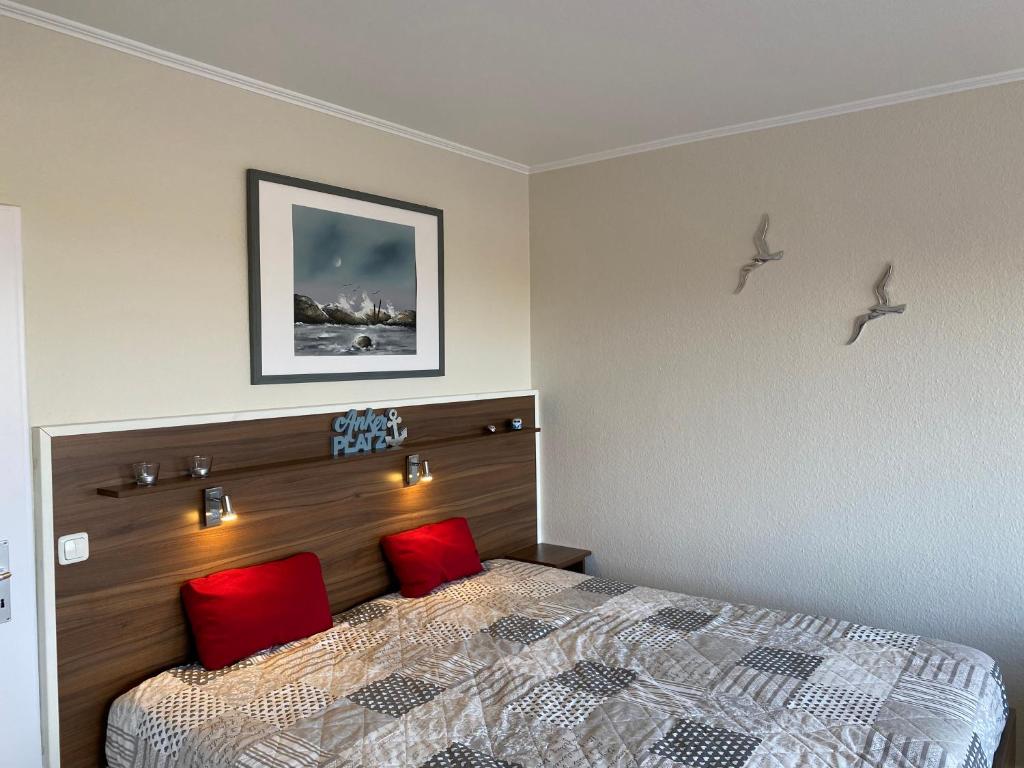 a bedroom with a bed and two red pillows at Marina View in Burgtiefe auf Fehmarn 